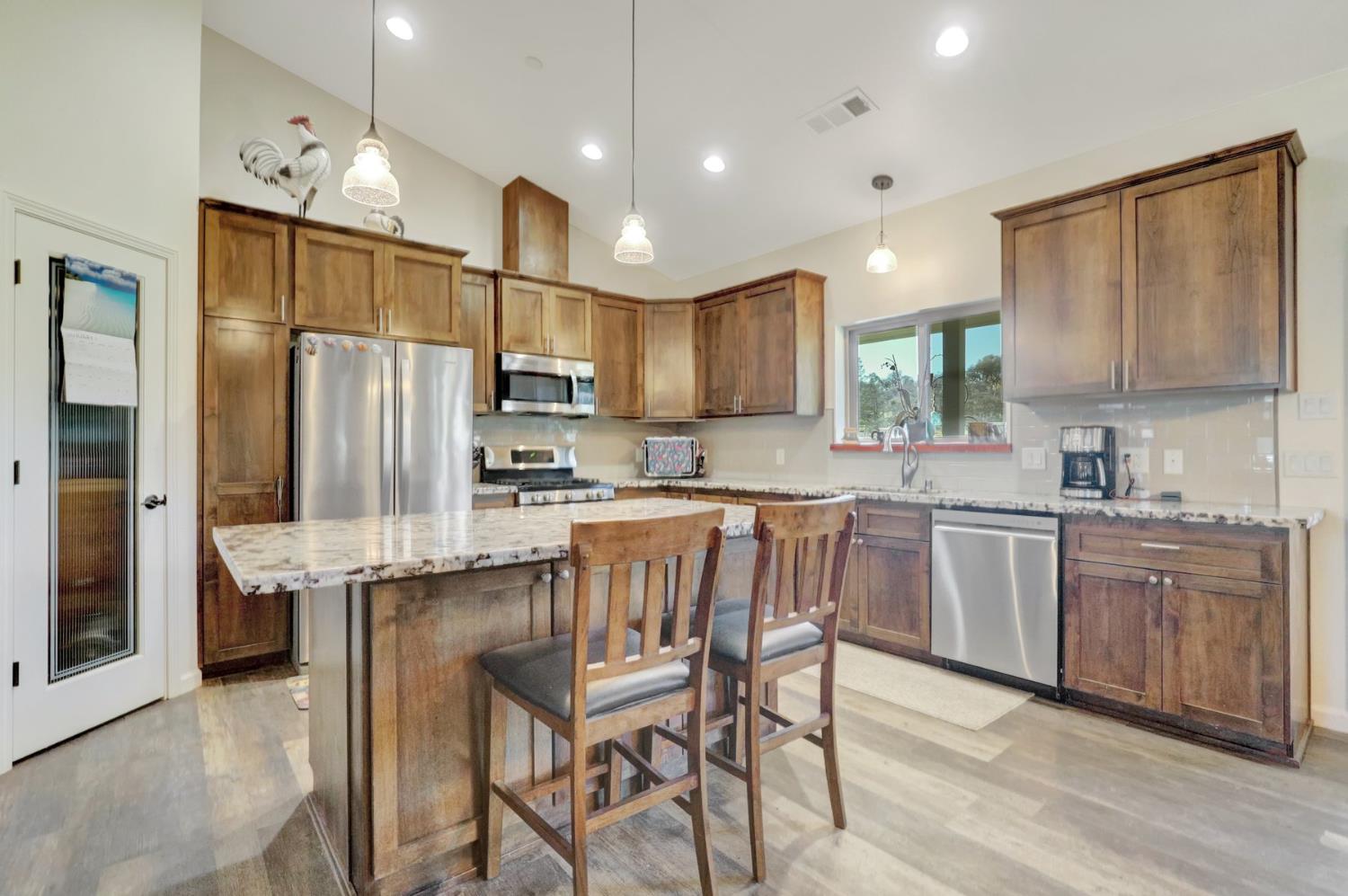6718 Cross Star Trail Loma Rica, CA 95901 - Photo 8 of 54 a kitchen with stainless steel appliances granite countertop a refrigerator a stove a sink a dining table and chairs