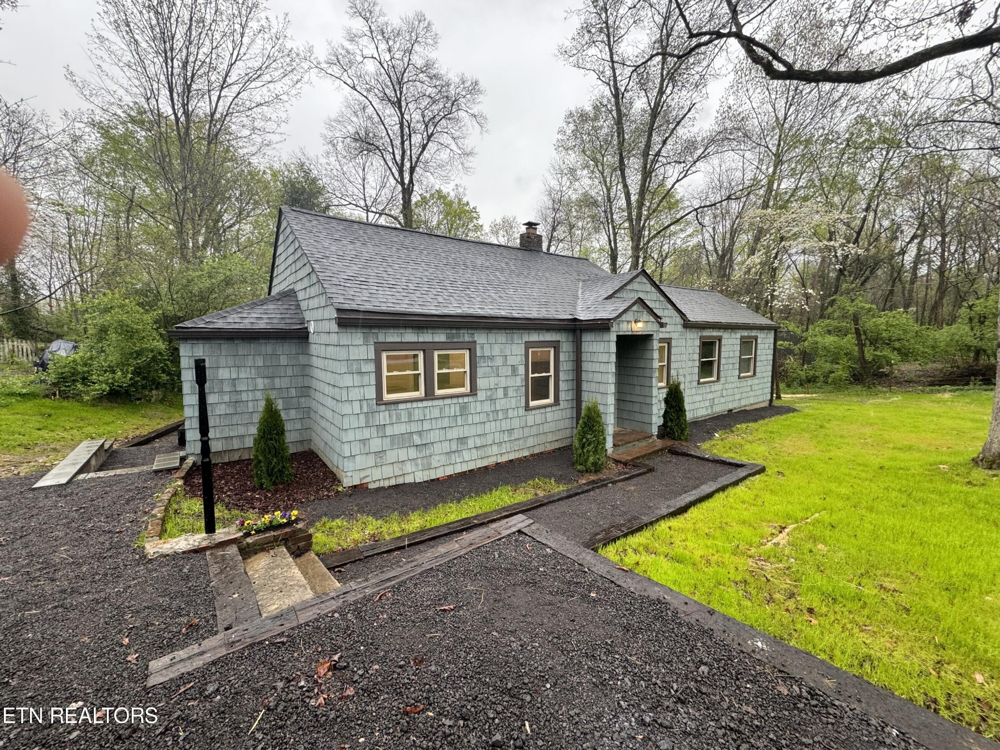 a view of a house with backyard and trees