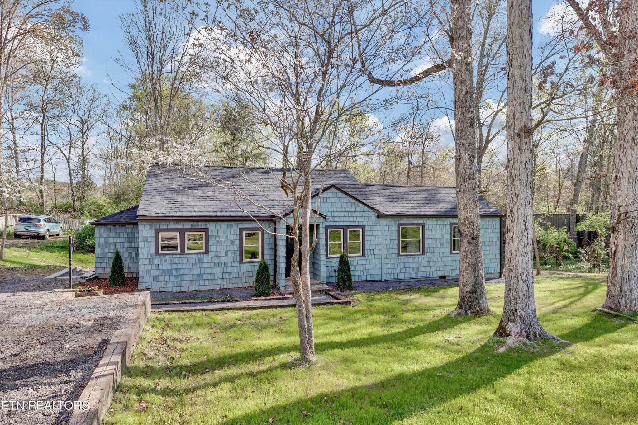 2209 Belt Road Knoxville, TN 37920 - Photo 7 of 36 a view of a yard in front of a brick house with a large tree