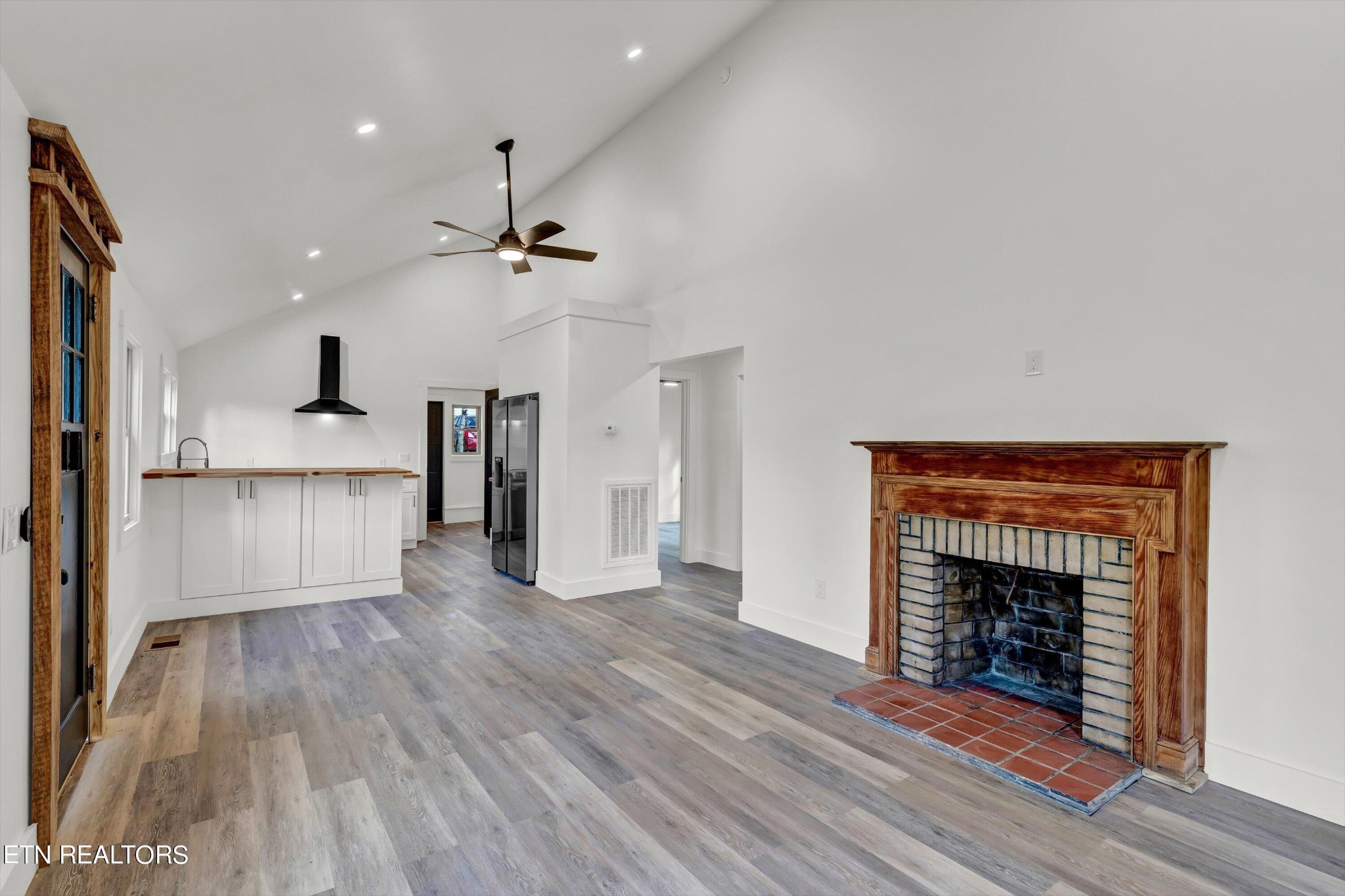 2209 Belt Road Knoxville, TN 37920 - Photo 8 of 36 a view of a kitchen and an empty room with wooden floor a fireplace