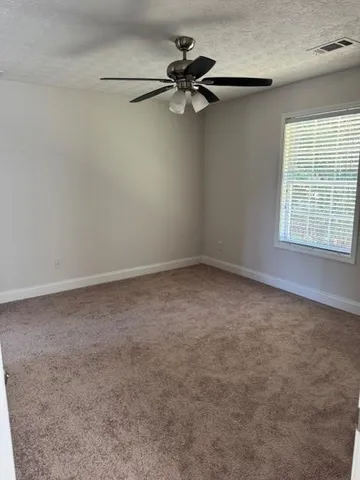 a view of a room with a window and a ceiling fan