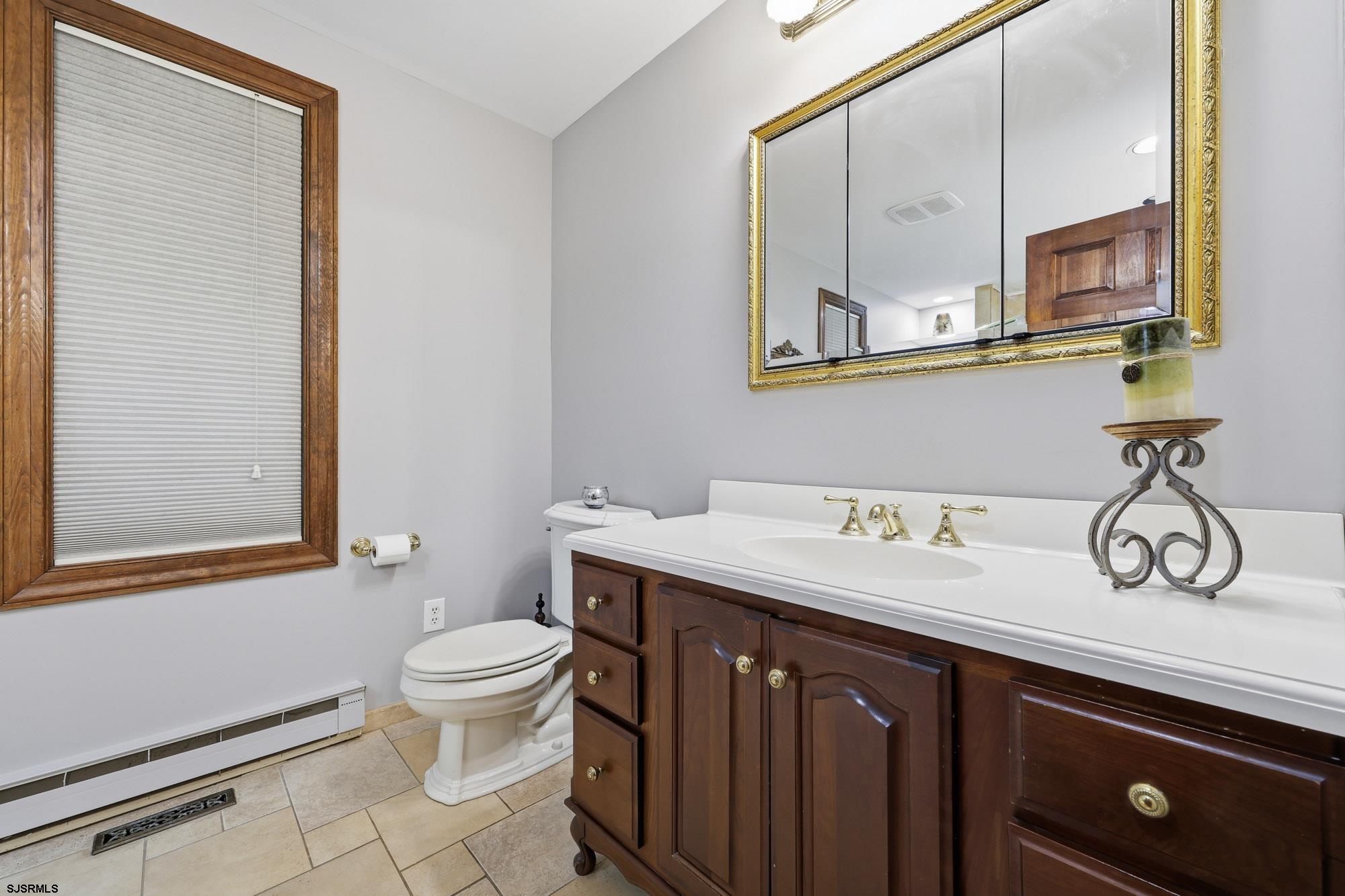 1202 Shore Road Northfield, NJ 08225 - Photo 28 of 57 a bathroom with a toilet a sink and a mirror