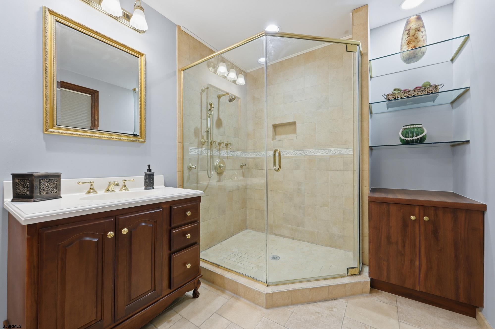 1202 Shore Road Northfield, NJ 08225 - Photo 29 of 57 a bathroom with a sink a mirror and a shower