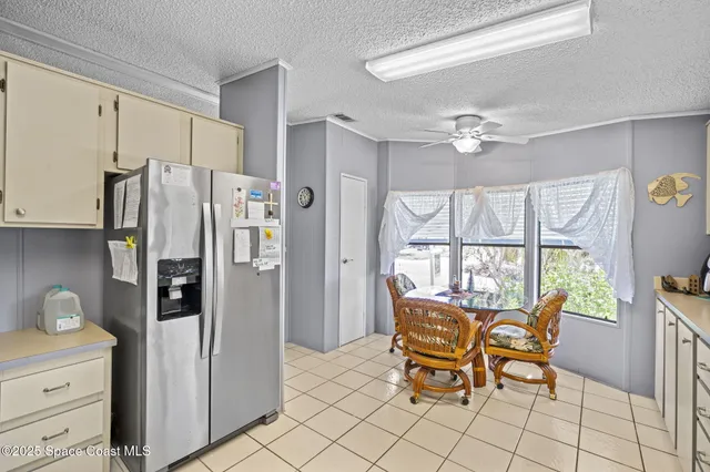 a kitchen with stainless steel appliances a refrigerator and a table chair