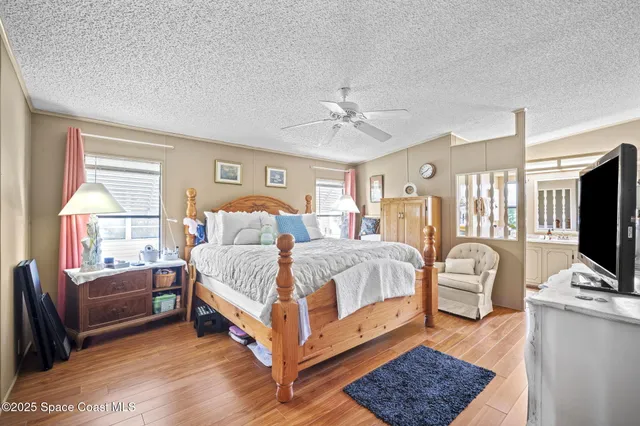 a bedroom with a bed wooden floor and window