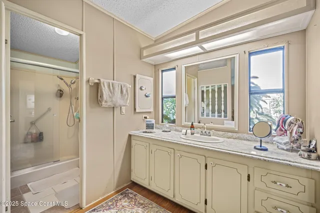 a bathroom with a double vanity sink mirror and shower