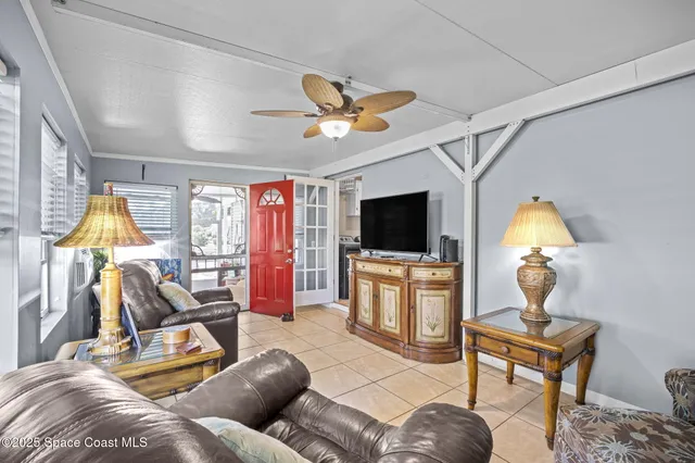 a living room with furniture a flat screen tv and a floor to ceiling window