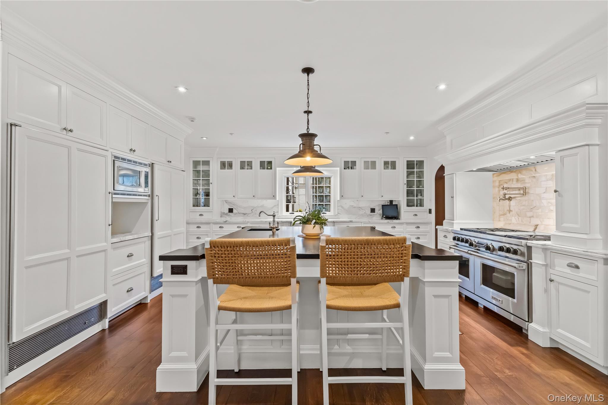 19 Park Drive South Rye, NY 10580 - Photo 14 of 42 Gourmet chef’s kitchen with custom white cabinetry, premium stainless steel appliances, and an oversized island with seating. Elegant finishes, warm hardwood floors, and abundant storage make this space both functional and stunning for everyday living and entertaining.