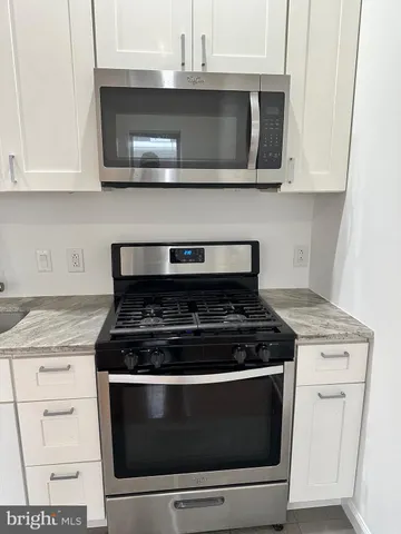 a stove top oven sitting inside of a kitchen
