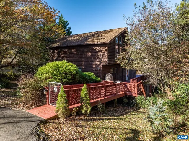 a view of a house with a yard and wooden fence