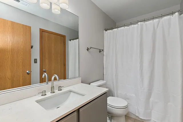 a bathroom with a sink a toilet and shower curtain