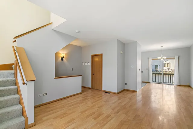 a view of a livingroom with wooden floor and stairs
