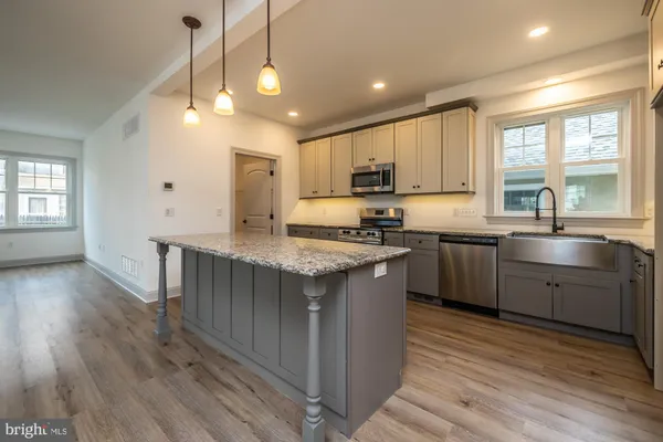 a kitchen with stainless steel appliances granite countertop a stove a sink and a refrigerator