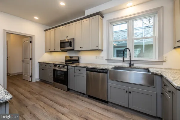 a bathroom with a granite countertop toilet and a sink