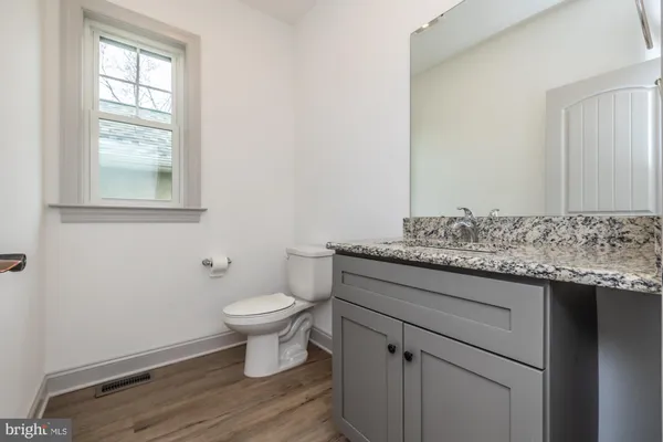 a bathroom with a granite countertop double vanity sink and mirror