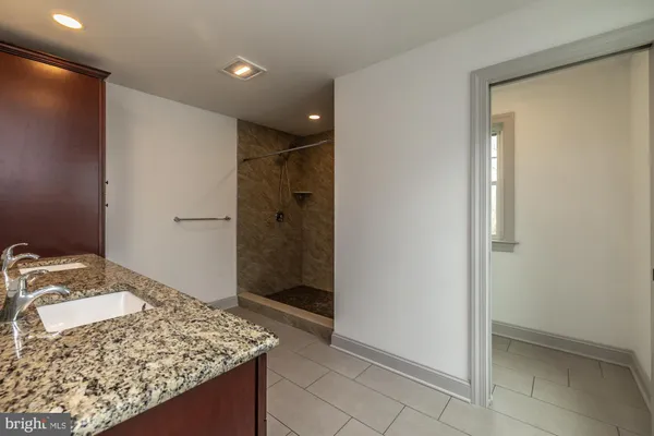 an empty room with wooden floor ceiling fan and windows