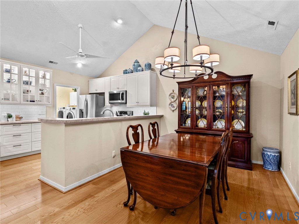 1338 Tannery Circle Midlothian, VA 23113 - Photo 14 of 37 a kitchen with stainless steel appliances kitchen island granite countertop a table chairs in it and wooden floors