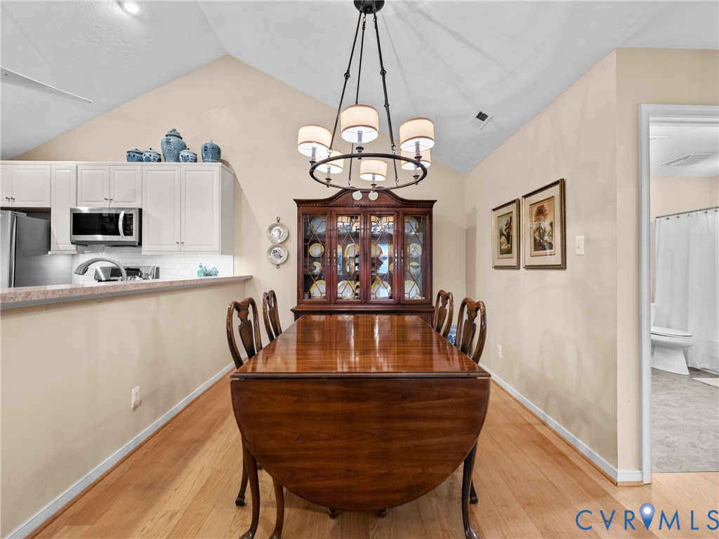 1338 Tannery Circle Midlothian, VA 23113 - Photo 15 of 37 a view of a dining room with furniture a chandelier and wooden floor