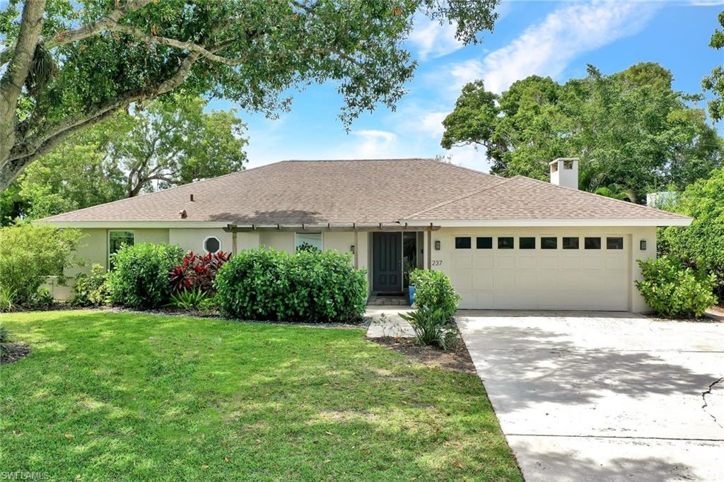 237 Burning Tree Drive Naples, FL 34105 - Photo 1 of 26 a house with green field in front of it