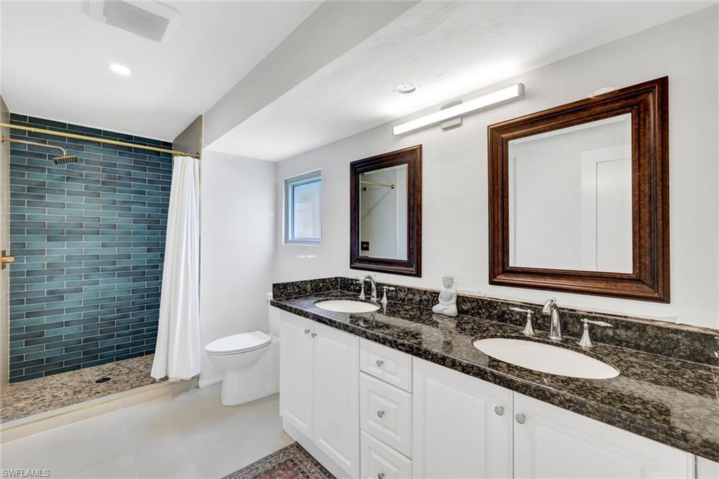 237 Burning Tree Drive Naples, FL 34105 - Photo 15 of 26 a bathroom with double sink and a mirror