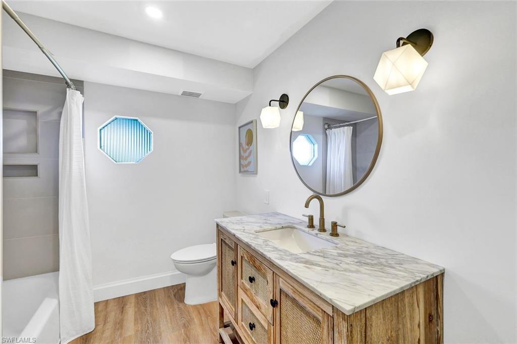 237 Burning Tree Drive Naples, FL 34105 - Photo 17 of 26 a bathroom with a granite countertop sink and a mirror