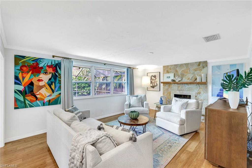 237 Burning Tree Drive Naples, FL 34105 - Photo 3 of 26 a living room with furniture a couch and paintings on the wall