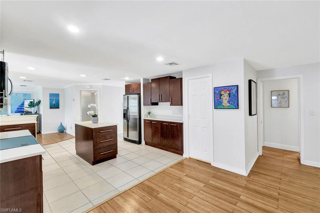 237 Burning Tree Drive Naples, FL 34105 - Photo 6 of 26 a living room with stainless steel appliances kitchen island granite countertop a refrigerator and a wooden cabinets