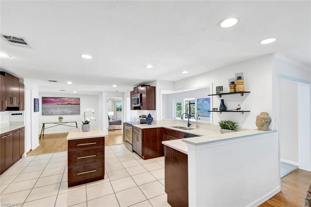 237 Burning Tree Drive Naples, FL 34105 - Photo 7 of 26 a kitchen with a sink stove and cabinets