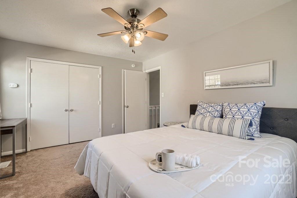 11320 Park Road Charlotte, NC 28226 - Photo 22 of 28 a spacious bedroom with a bed and a chandelier