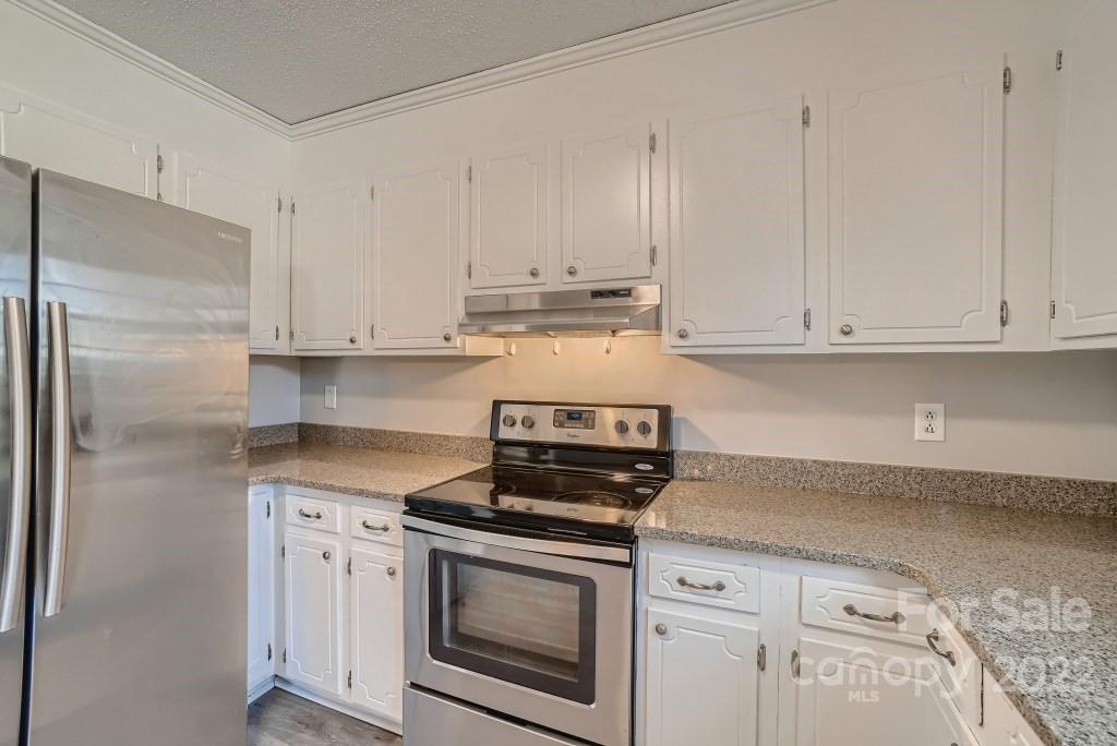 11320 Park Road Charlotte, NC 28226 - Photo 6 of 28 a kitchen with granite countertop white cabinets and stainless steel appliances
