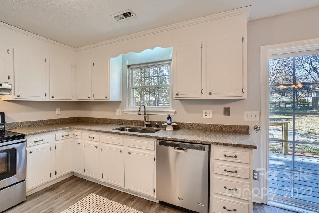 11320 Park Road Charlotte, NC 28226 - Photo 7 of 28 a kitchen with granite countertop white cabinets and white appliances