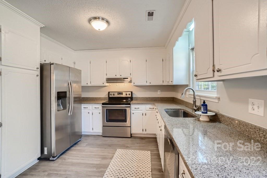 11320 Park Road Charlotte, NC 28226 - Photo 8 of 28 a kitchen with granite countertop a sink stove and refrigerator