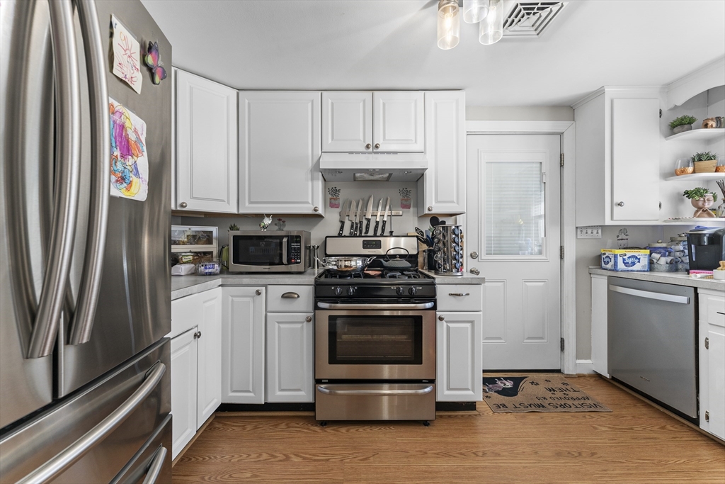 74 Benson Street Whitman, MA 02382 - Photo 11 of 30 a kitchen with a stove and a refrigerator