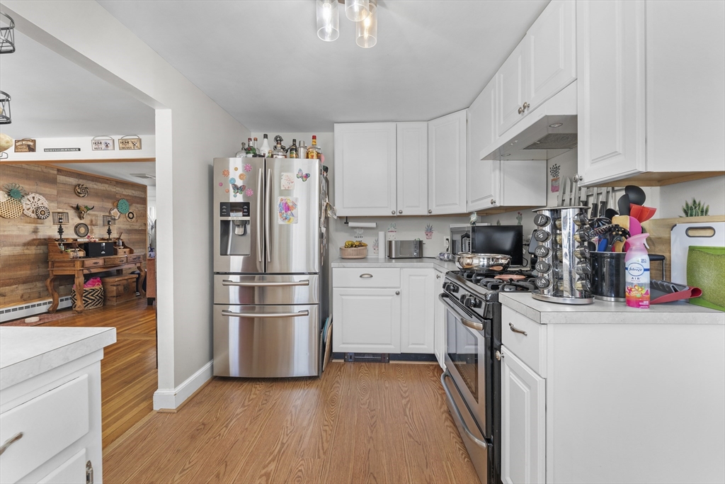 74 Benson Street Whitman, MA 02382 - Photo 13 of 30 a kitchen with a refrigerator a stove and wooden floor