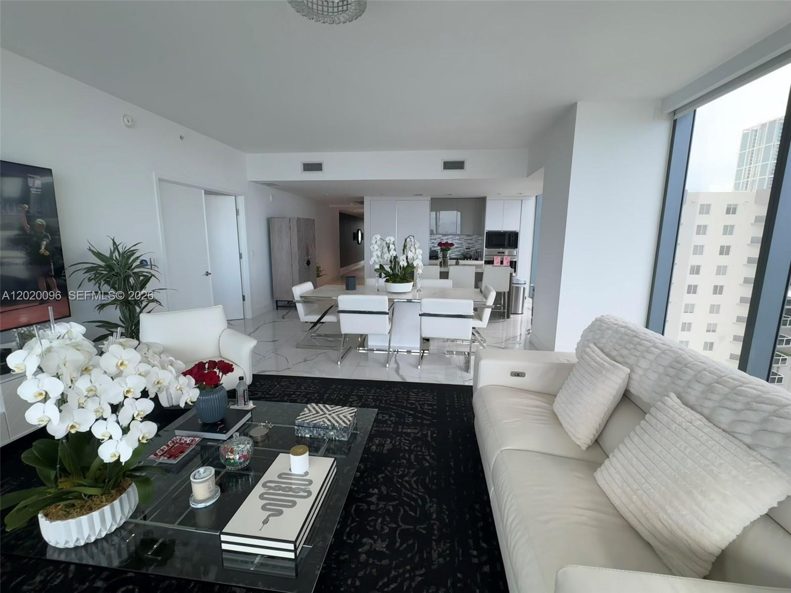 788 Northeast 23rd Street, Unit 1202 Miami, FL 33137 - Photo 10 of 64 a living room with furniture and flowers