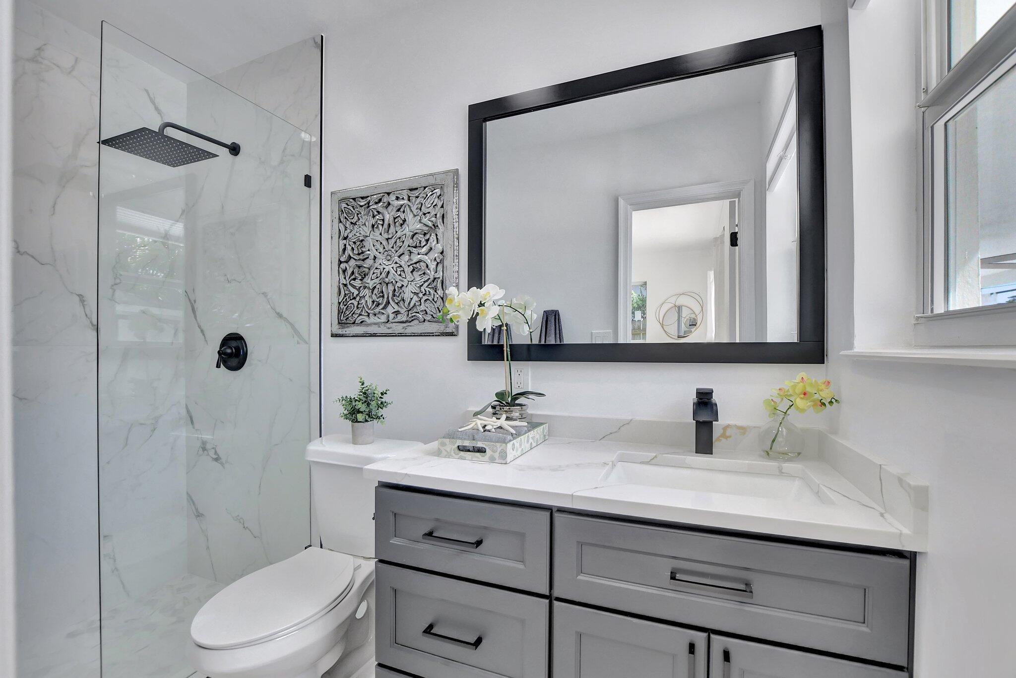 832 Southwest 10th Avenue Boca Raton, FL 33486 - Photo 24 of 57 a bathroom with a sink toilet a mirror a shower and vanity