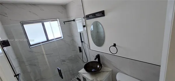 a bathroom with a shower a toilet and a mirror