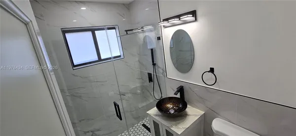 a bathroom with a mirror and a fan