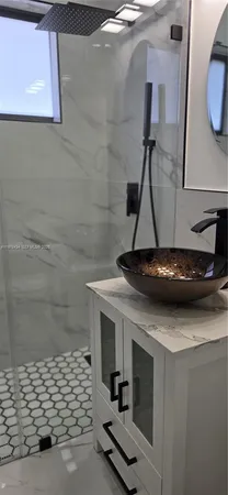 a bathroom with a sink a mirror and shower