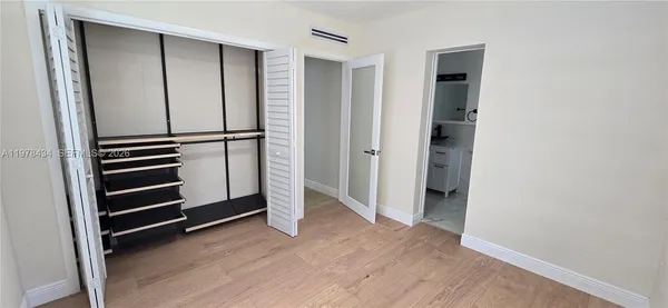 an empty room with wooden floor and closet