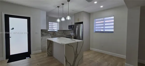 a kitchen with a refrigerator a sink and cabinets