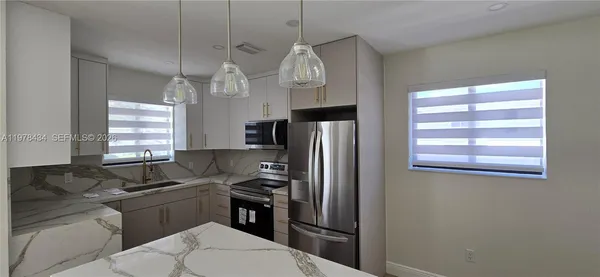 a kitchen with a refrigerator a sink and dishwasher a stove top oven with wooden floor