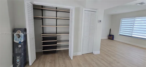 a view of walk in closet with empty racks
