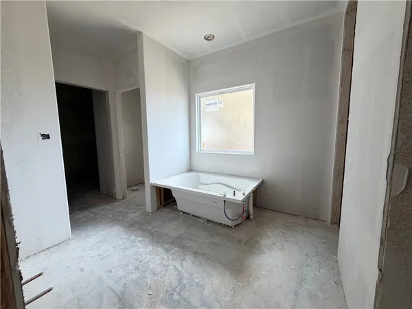 a spacious bedroom with a bed and a window