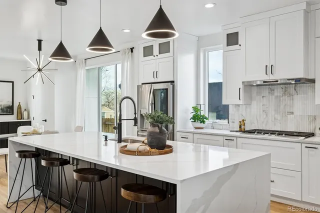 a kitchen with stainless steel appliances a sink a stove and cabinets