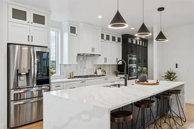 a kitchen with stainless steel appliances a sink a stove a refrigerator and cabinets