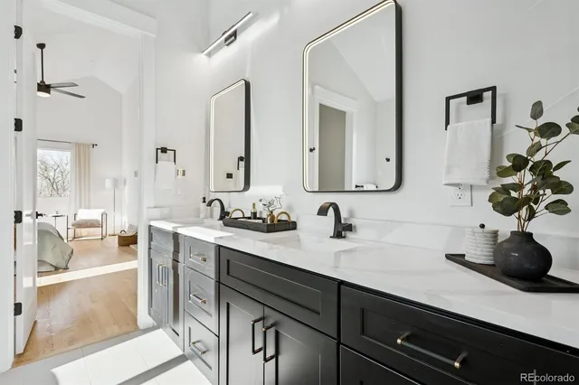 a bathroom with double vanity sinks a mirror and a bathtub