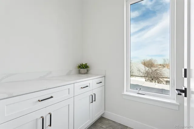 a kitchen with granite countertop white cabinets and a window