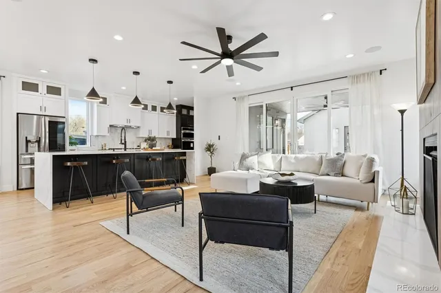 a living room with furniture kitchen view and a chandelier