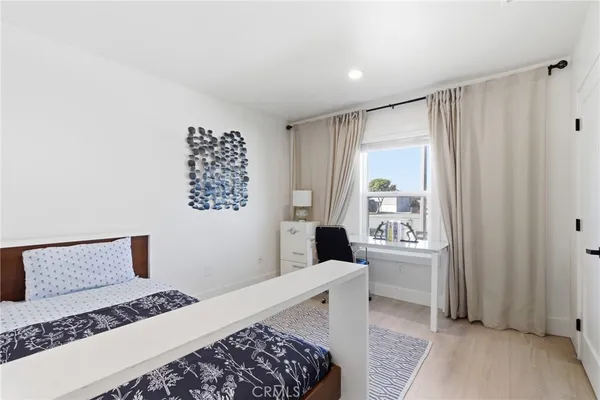 a bedroom with a large bed and a potted plant